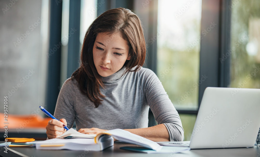 Wall mural Woman taking down notes in diary