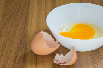 Eggs in white cup and Eggshell,on wood background
