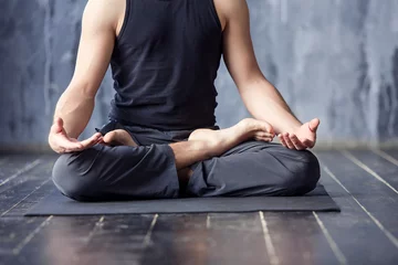  Jonge mannen doen yoga binnenshuis op zwarte mat © 4frame group