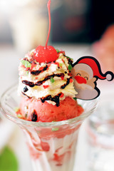 Strawberry ice cream, whipped cream, cherries on the top.