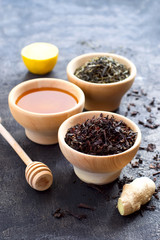 Selection of dry tea, a bowl with honey, ginger and lemon