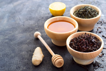 Selection of dry tea, a bowl with honey, ginger and lemon. copy