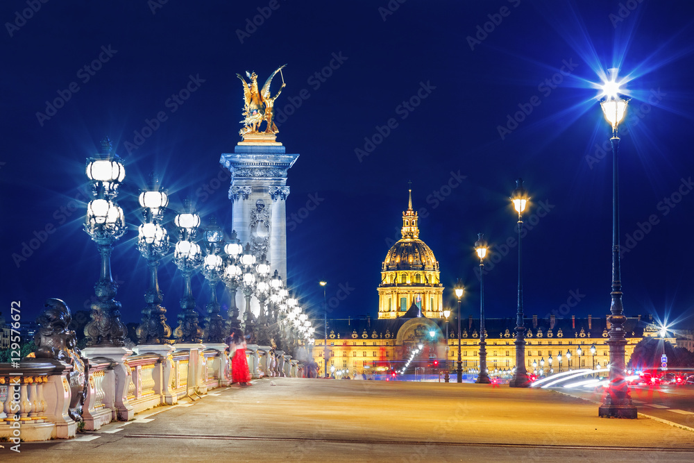 Wall mural Alexandre III Bridge, Paris France. Night scene of cityscape with lights. Invalide palace at background.