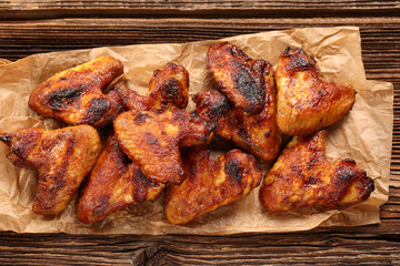 Chicken wings baked in a pan on wooden background