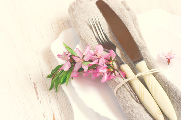 table setting with flowering almonds close-up. Spring white back