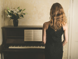 Beautiful woman in dress by piano