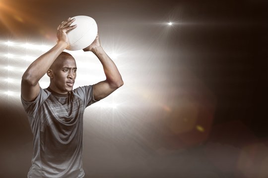 Composite image of confident sportsman throwing rugby ball 3D