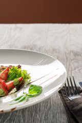 Salad greens, cheese and strawberries with balsamic sauce.