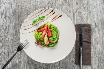 Salad greens, cheese and strawberries with balsamic sauce.