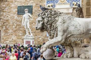 Piazza della Signoria with a lion statue and the replica of Michelangelo`s David, Florence, Italy