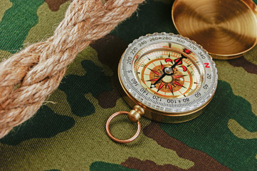 Compass and rope on a camouflage background