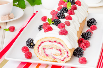 Vanilla roulade with raspberry jam and butter cream on a white background
