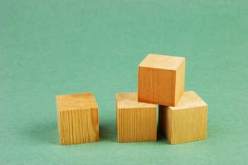 wooden geometric cube on a green background