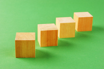 wooden geometric cube on a green background