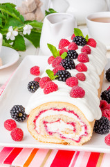 Vanilla roulade with raspberry jam and butter cream on a white background