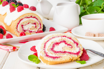 Vanilla roulade with raspberry jam and butter cream on a white background