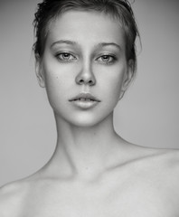Beauty portrait of young blonde model with nude makeup. Black and white.