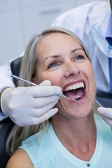 Dentist examining a woman with tools