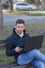 Fototapeta premium Portrait of a bearded man holding mobile phone and looking at ca