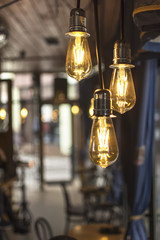 Fototapeta na wymiar Old Style Glowing Light Bulbs Hanging in Bar