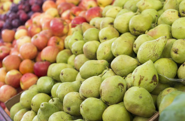 Pears, apples and plums on display at a farmer's market. Fruit background. Healthy eating. Fall harvest agricultural agriculture concept (selective focus)