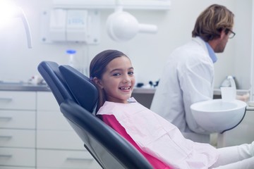 Obraz premium Smiling young patient sitting on dentists chair