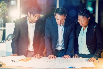 Group of businesspeople discussing over blueprint