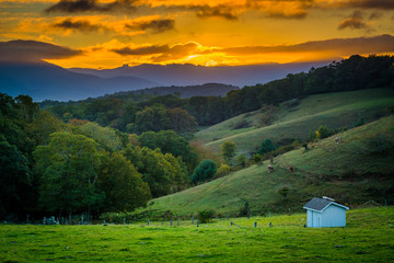 Sunset over rolling hills and farm fields at Moses Cone Park on