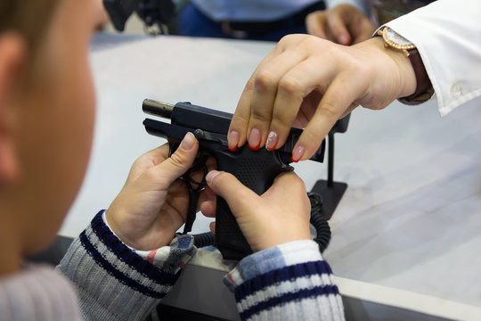Child examines a gun at the counter in the store