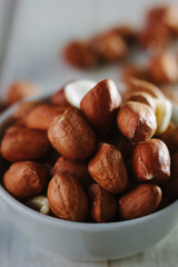 Dry peanuts in white bowl over the white table