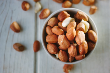 Dry peanuts in white bowl over the white table