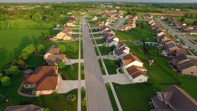 Beautiful, suburban houses with landscaped yards, early morning, aerial view.
