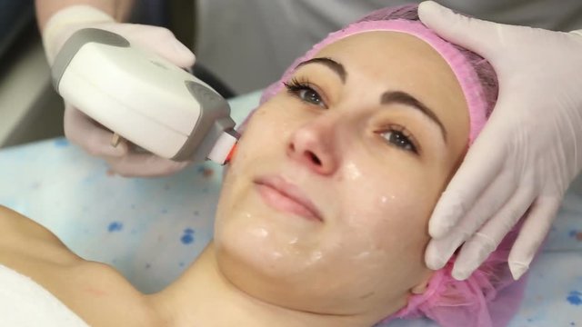 Young woman doing cosmetology laser therapy