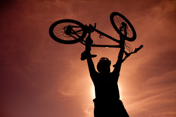 Silhouette of a man with a bike