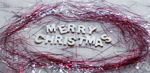 Wooden white "Merry christmas" with sparkly decor on wooden background.