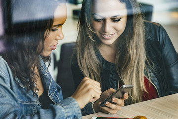 two young girls talking in a cafeteria