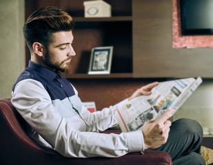 Fototapeta na wymiar Young man reading newspaper