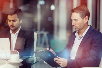 Businessman writing on clipboard