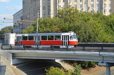 Fototapeta na wymiar Трамвай проезжает по трамвайному путепроводу в Москве