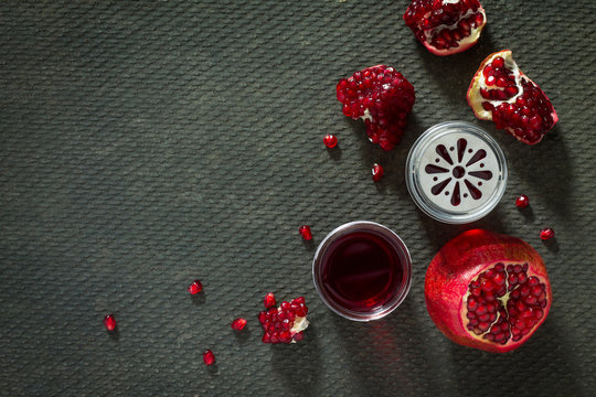Pomegranate and pomegranate juice on a concrete gray background.