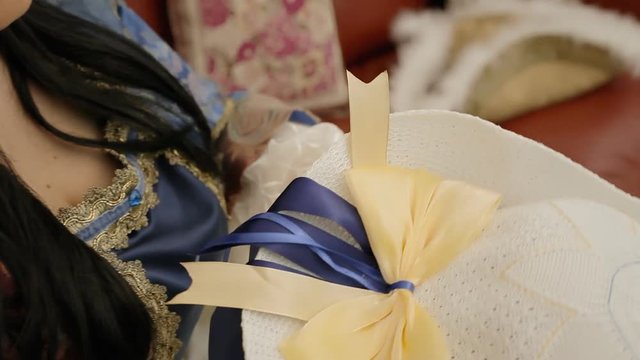 The servant of an 18th century aristocratic family admiring a beautiful hat.
