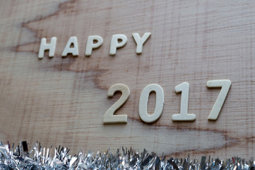 Wooden white "Happy 2017" with christmas decor on wooden background.