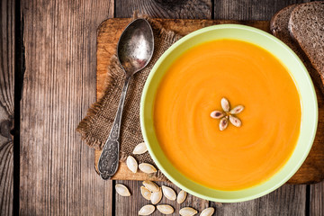 Pumpkin soup on rustic wooden background