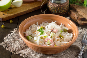 Salad with sauerkraut, ham, apple and green peas. Snack on a fes