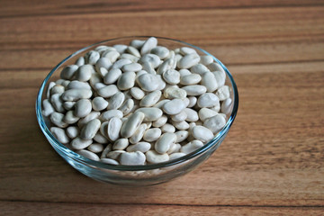 White beans in a bowl on a wooden table