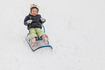 Girl sledging down hills winter