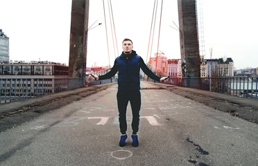 Athlete jumping skipping rope on a city bridge