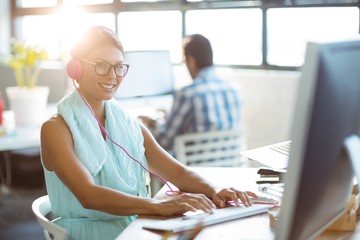 Obraz premium Business executive listening to music while working on computer