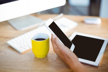 Hand of business executive holding mobile phone