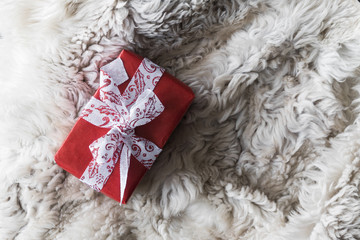 wrapped in red kraft paper gift for happy holiday on fur coat